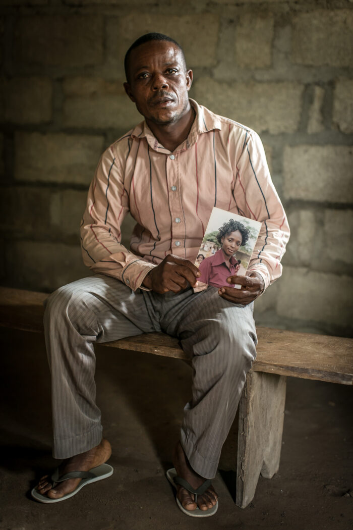 A man holds a photograph of his wife Janet, who died from postpartum hemorrhage after giving birth.